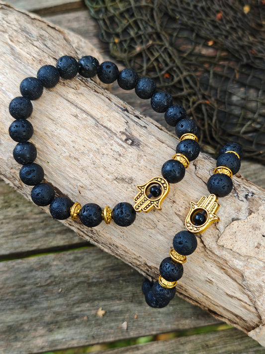 Armband mit Lava-Stein und goldenen Hamsa-Anhänger