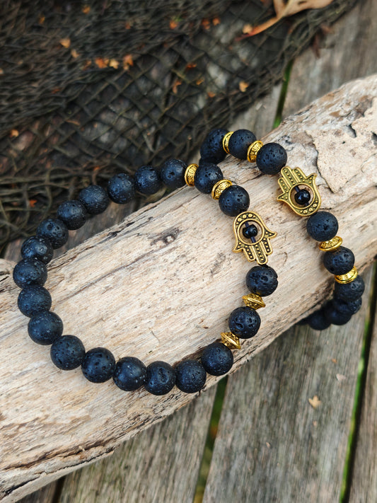 Armband mit Lava-Stein und goldenen Hamsa-Anhänger