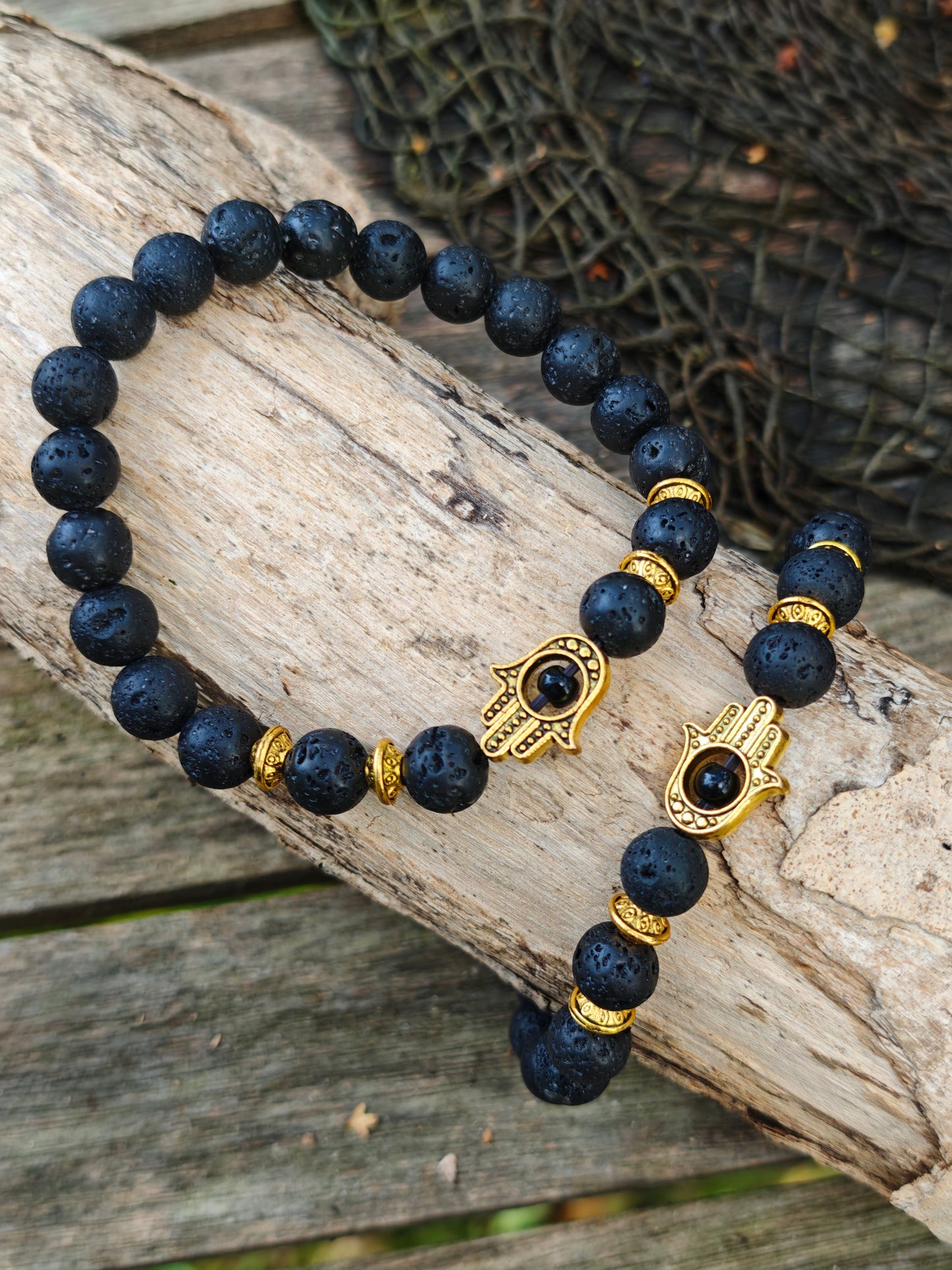 Armband mit Lava-Stein und goldenen Hamsa-Anhänger